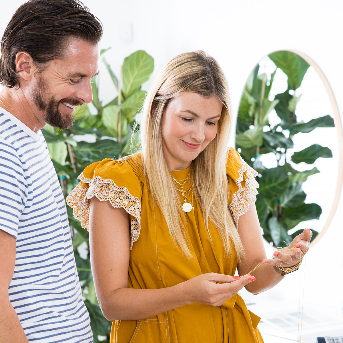 Co founders Gorjana and Jason Reidel looking at gorjana necklaces.